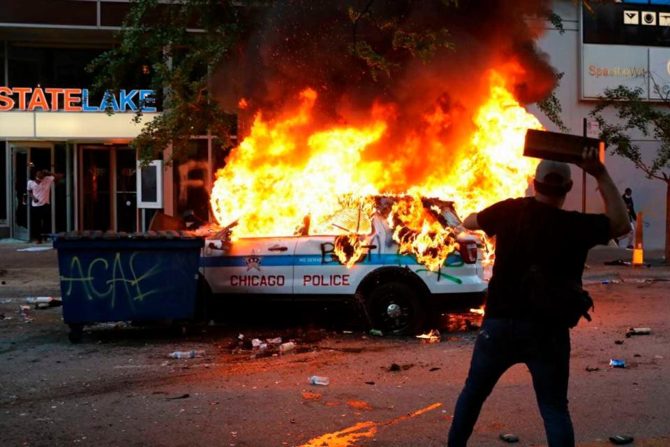 A Chicago police vehicle is set on fire during violent protests Saturday, May 30, 2020, as outrage builds over the killing of George Floyd, a black man who died in Minneapolis on May 25 after a police officer pressed his knee into his neck for several minutes.