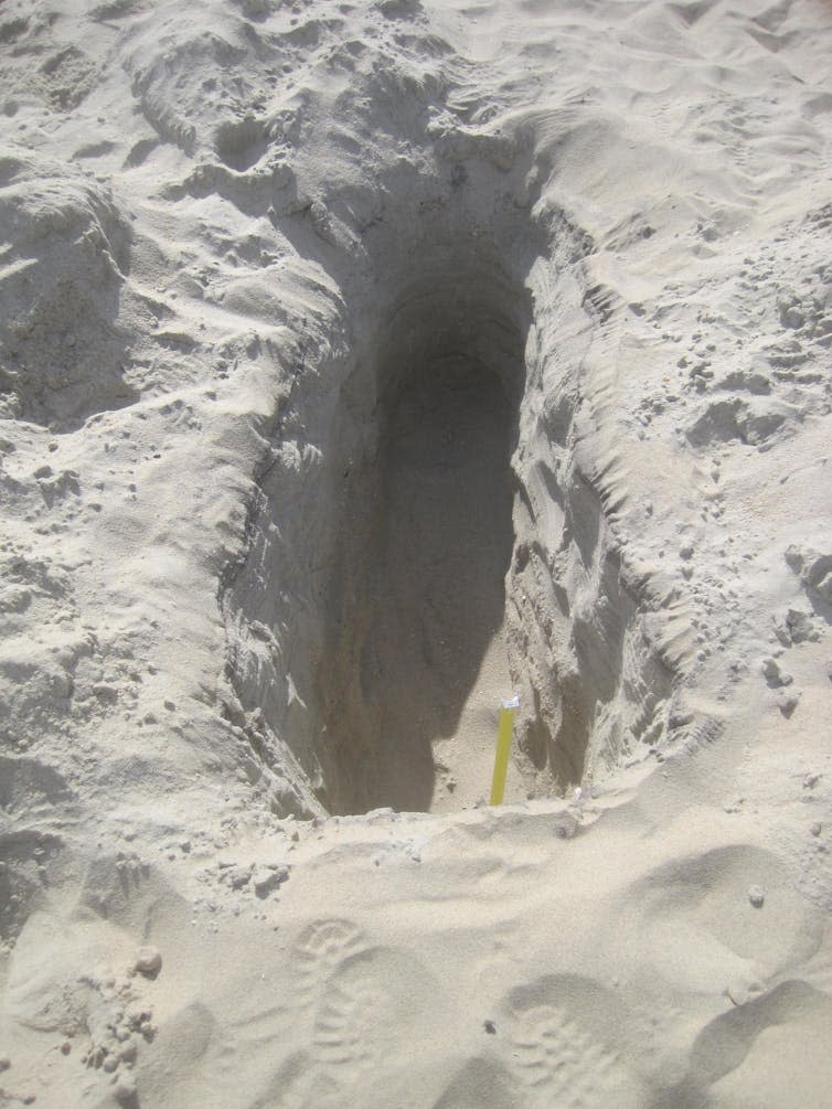 A long, narrow sand hole that's about two feet deep.