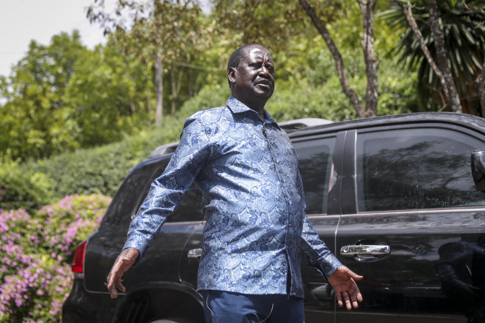 Kenya's opposition leader Raila Odinga stands next to one of his vehicles he says was struck by a teargas canister fired by riot police, at his home in Nairobi, Kenya Friday, March 31, 2023. In an interview with The Associated Press on Friday, Odinga denounced the point-blank firing of a tear gas canister at local journalists during his latest anti-government protest as a "primitive act of intolerance" and vowed to go to court over what he called an attempt on his own life. (AP Photo/Brian Inganga)