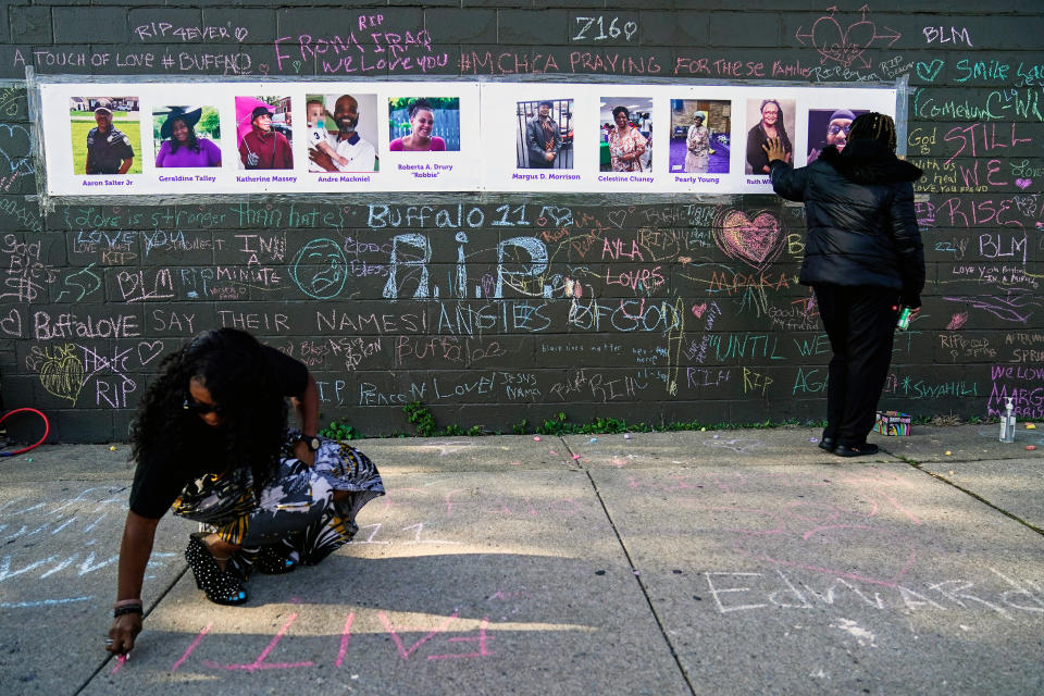 FILE - People pay their respects at a makeshift memorial near the scene of a mass shooting at a supermarket in Buffalo, Thursday, May 19, 2022. The victims of the mass shooting will be honored with a permanent memorial in the neighborhood. Gov. Kathy Hochul and Mayor Byron Brown on Friday, Oct. 21, 2022, announced the creation of a commission tasked with planning and overseeing construction of a monument in East Buffalo. (AP Photo/Matt Rourke, File)