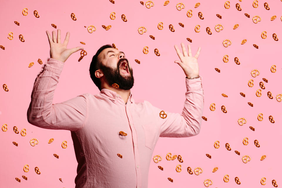 Man trying to eat flying pretzels