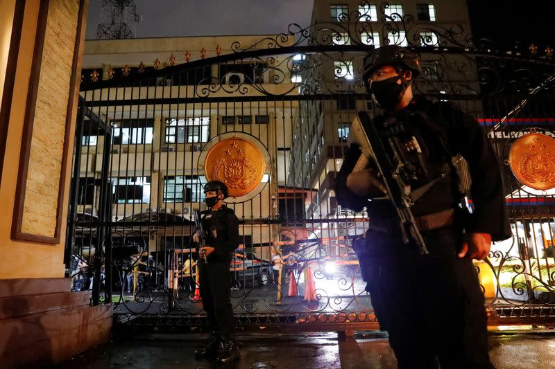 Armed police officers stand guard outside the gate of national police headquarters, in Jakarta