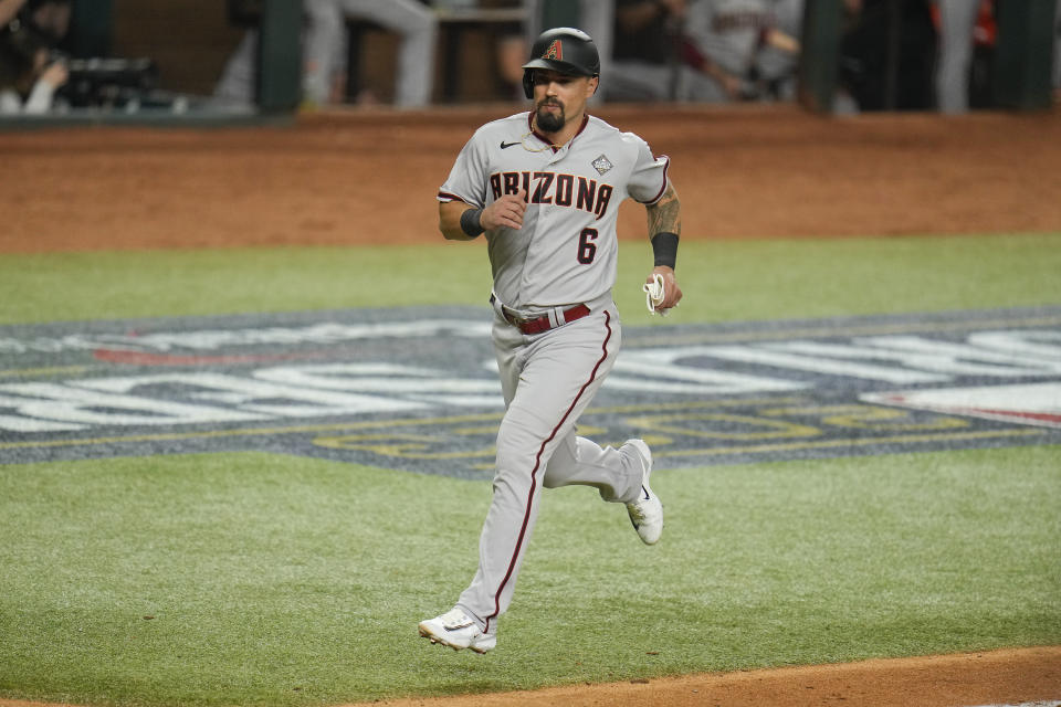 Arizona Diamondbacks' Jace Peterson scores on a two-run single by Emmanuel Rivera during the ninth inning in Game 2 of the baseball World Series against the Texans Rangers, Friday, Oct. 27, 2023, in Arlington, Texas. Diamondbacks' Tommy Pham had a chance to become the first player to go 5 for 5 in a World Series game but asked to have Peterson pinch hit for him to ensure his teammate a Series appearance. (AP Photo/Julio Cortez)