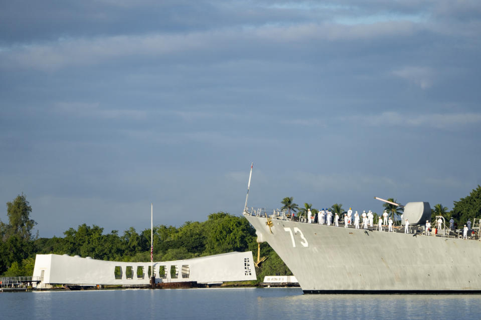 Sailors aboard the the USS Decatur render honors while passing the USS Arizona Memorial and the sunken battleship the USS Arizona during the 82nd Pearl Harbor Remembrance Day ceremony on Thursday, Dec. 7, 2023, at Pearl Harbor in Honolulu, Hawaii. (AP Photo/Mengshin Lin)