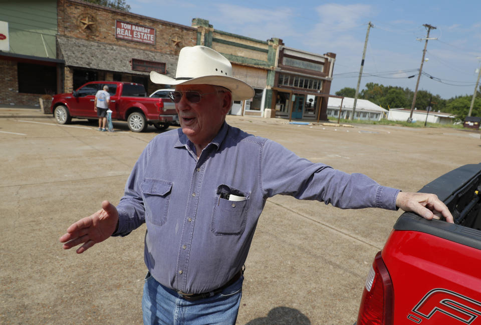 In this Aug. 5, 2019, photo, Tom Ramsay stands near his office in the town square as he responds to questions about Art Briles and his position as the head coach at Mount Vernon High School football team in Mount Vernon, Texas. “I think we’re lucky to have him and I’m going to support him 100 percent,” said Ramsay, a former five-term state representative whose real estate office is on the town square. “(AP Photo/Tony Gutierrez)