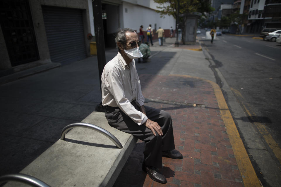 Un hombre que usa una máscara para protegerse del coronavirus permanece sentado el domingo 24 de mayo de 2020 en un banco en Caracas, Venezuela. (AP Foto/Ariana Cubillos)