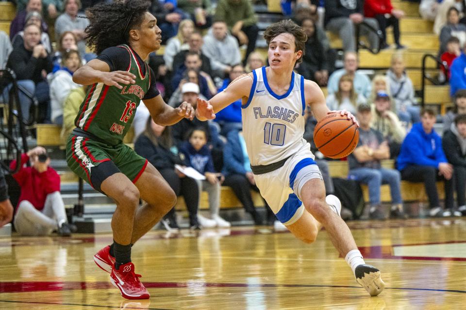 Franklin Central High School senior Josh Moriarty (10) drives the ball around the defense of Lawrence North High School senior Kobi Bowles (13) during the first half of a Boysâ€™ Marion County Basketball Tournament championship game, Saturday, Jan. 13, 2024, at Southport High School.