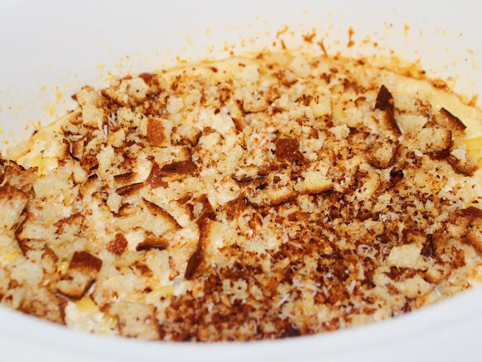 cooked mac and cheese in slow cooker topped with breadcrumbs