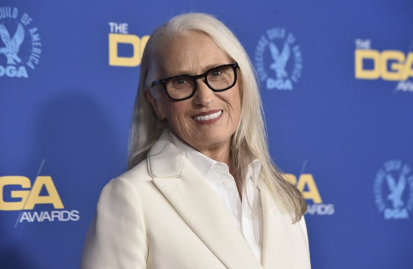 Jane Campion posing in glasses and a white suit