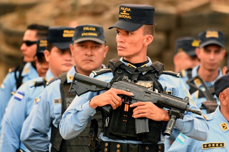 Honduran National Police members take position during security operations in Lomas del Carmen (Orlando SIERRA)