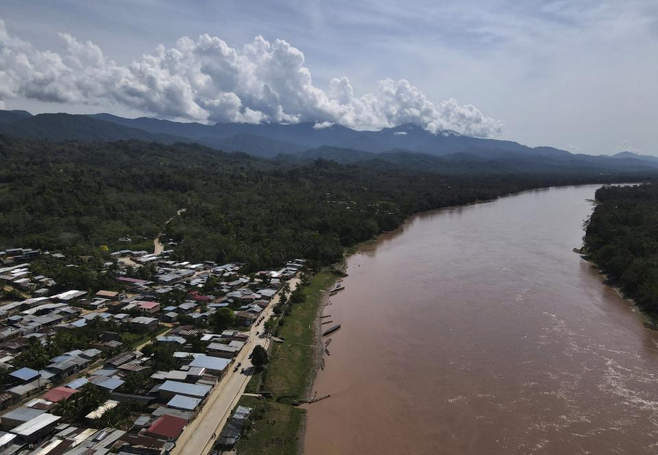 A river flows near the Chazuta community with the Cordillera Azul National Park in the background, in Peru's Amazon, Sunday, Oct. 2, 2022. Residents in Kichwa Indigenous villages in Peru say they fell into poverty after the government turned their ancestral forest into a national park, restricted hunting and sold forest carbon credits to oil companies. (AP Photo/Martin Mejia)