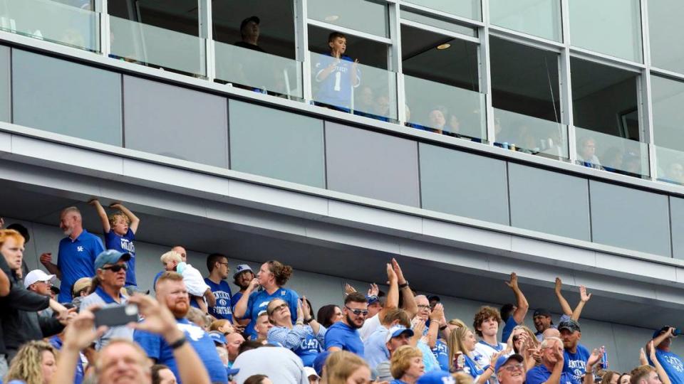 A young Kentucky fan cheers from a fifth-floor suite as other spectators below him applaud a play from the upper deck during last Saturday’s UK football game against Eastern Kentucky at Kroger Field. Originally named Commonwealth Stadium, the venue arrived Friday at the 50th anniversary of its opening on Sept. 15, 1973.