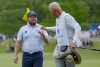 Zac Blair, left, fist-bumps the caddie of Patrick Fishburn after their team finished the third round of the PGA Zurich Classic golf tournament at TPC Louisiana in Avondale, La., Saturday, April 27, 2024. (AP Photo/Matthew Hinton)