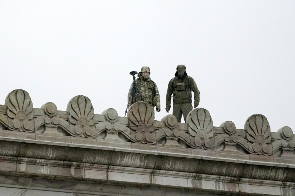 Law enforcement officers stand atop the Capitol in anticipation of protests Monday, Jan. 11, 2021, at the Capitol in Olympia, Wash. According to organizers, some protesters are unhappy the Legislature will be meeting virtually and in sessions not open to the public, due to the COVID-19 pandemic, during the 2021 session which opens Monday. Washington Gov. Jay Inslee activated members of the National Guard this week to work with the Washington State Patrol to protect the Capitol campus. (AP Photo/Ted S. Warren)