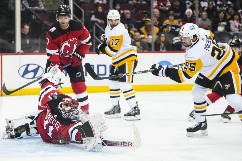 New Jersey Devils' Vitek Vanecek stops a shot on goal by Pittsburgh Penguins' Ryan Poehling (25) during the third period of an NHL hockey game, Sunday, Jan. 22, 2023, in Newark, N.J. The Devils won 2-1 in overtime. (AP Photo/Frank Franklin II)