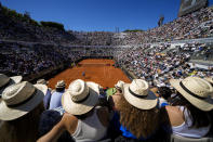 Spectators watch Chile's Alejandro Tabilo, top, return the ball to Germany's Alexander Zverev during a men's tennis semifinal match at the Italian Open tennis tournament, in Rome, Friday, May 17, 2024. (AP Photo/Andrew Medichini)