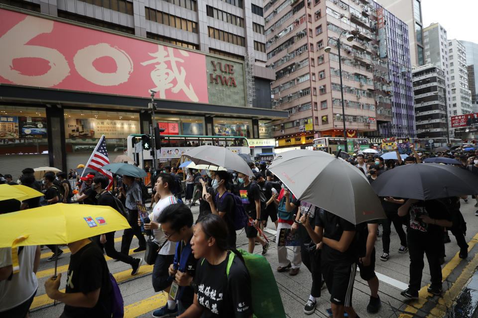 Protesters march through the Mong Kok neighborhood during a demonstration in Hong Kong, Saturday, Aug. 3, 2019. Hong Kong protesters ignored police warnings and streamed past the designated endpoint for a rally Saturday in the latest of a series of demonstrations targeting the government of the semi-autonomous Chinese territory. (AP Photo/Vincent Thian)
