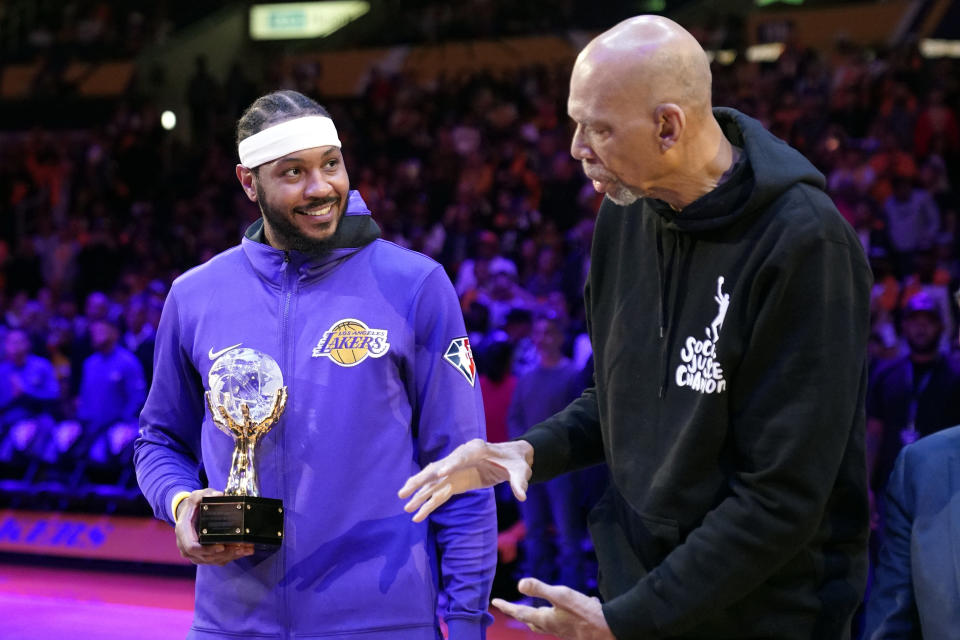 FILE -Former Los Angeles Lakers center Kareem Abdul-Jabbar, right, hands Los Angeles Lakers' Carmelo Anthony the Kareem Abdul-Jabbar Trophy for the league's annual Social Justice Champion prior to an NBA basketball game against the Denver Nuggets Sunday, April 3, 2022, in Los Angeles. Kareem Abdul-Jabbar's reign atop the NBA career scoring list is about to end after nearly four decades. LeBron James is on the verge of passing Abdul-Jabbar for the record that he's held since 1984.(AP Photo/Mark J. Terrill, File)