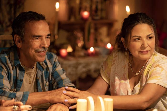 two characters holding hands as they sit at a table