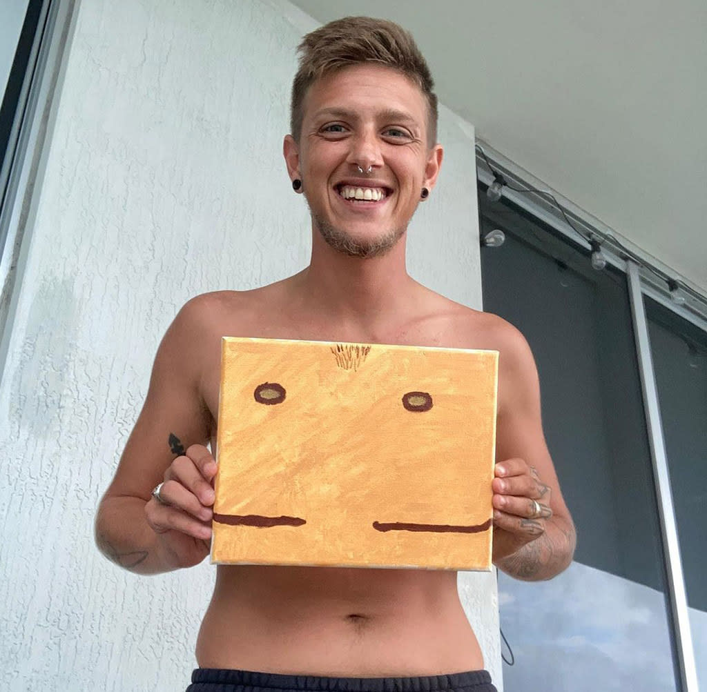 Noah Boutilier holding one of his top-surgery paintings. (Photo: Instagram/@noah_withnoark)