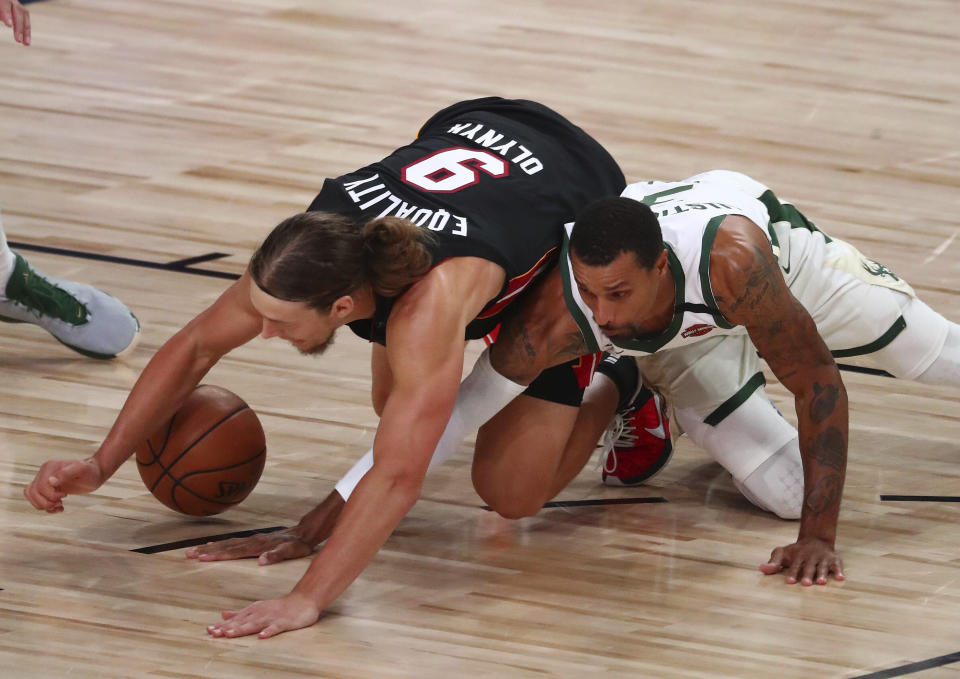 Miami Heat forward Kelly Olynyk (9) and Milwaukee Bucks guard George Hill (3) play for the ball during the second half of an NBA basketball game Thursday, Aug. 6, 2020, in Lake Buena Vista, Fla. (Kim Klement/Pool Photo via AP)