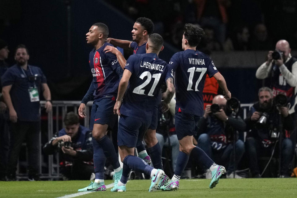 PSG's Kylian Mbappe, left, celebrates with his teammates after scoring his side's opening goal during the Champions League group F soccer match between Paris Saint Germain and AC Milan at Parc des Princes stadium in Paris, Wednesday, Oct. 25, 2023. (AP Photo/Thibault Camus)