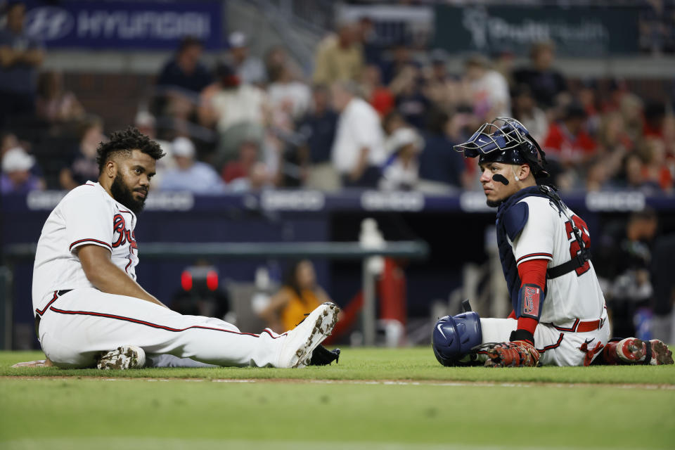 Atlanta Braves relief pitcher Kenley Jansen, left, and catcher William Contreras, right, take a break after the home plate umpire was hit in the ninth inning of a baseball game against the Miami Marlins, Saturday, Sept. 3, 2022, in Atlanta. (AP Photo/Bob Andres)