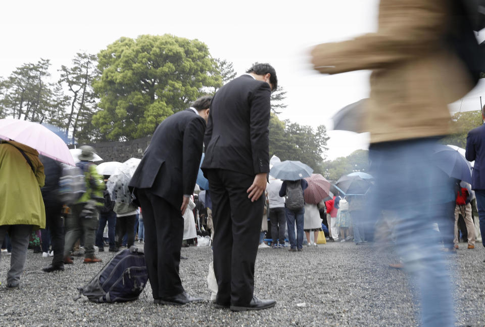 People bow toward the Imperial Palace as Emperor Akihito's abdication ceremony is held in Tokyo Tuesday, April 30, 2019. Emperor Akihito announced his abdication at the palace ceremony Tuesday in his final address, as the nation embraced the end of his reign with reminiscence and hope for a new era. (Shinji Kita/Kyodo News via AP)