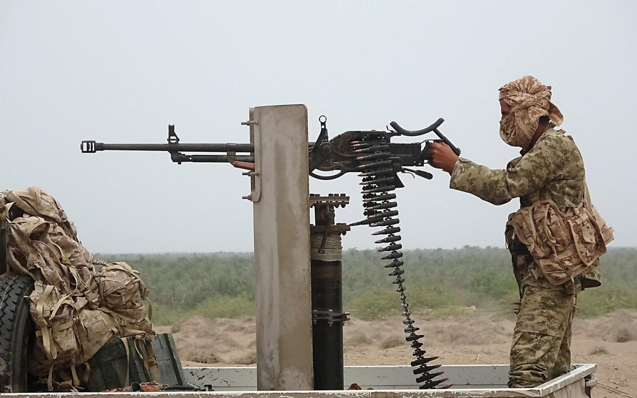 A pro-government Yemeni soldier fires a machine gun near the city of Al Hajjah in Yemen's Hodeida province - AFP