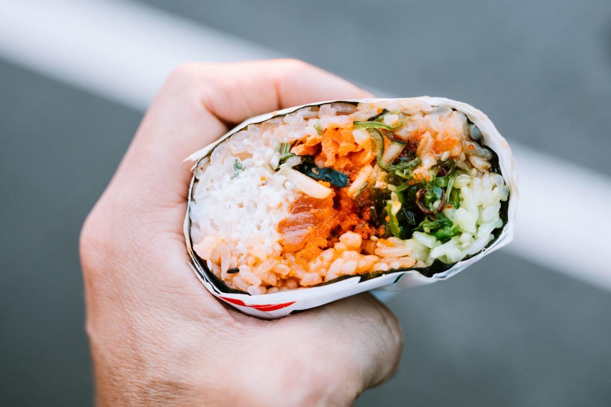 A unique fusion food, a sushi burrito is a similar to a traditional sushi roll except it isn't sliced and is eaten like a regular burrito.