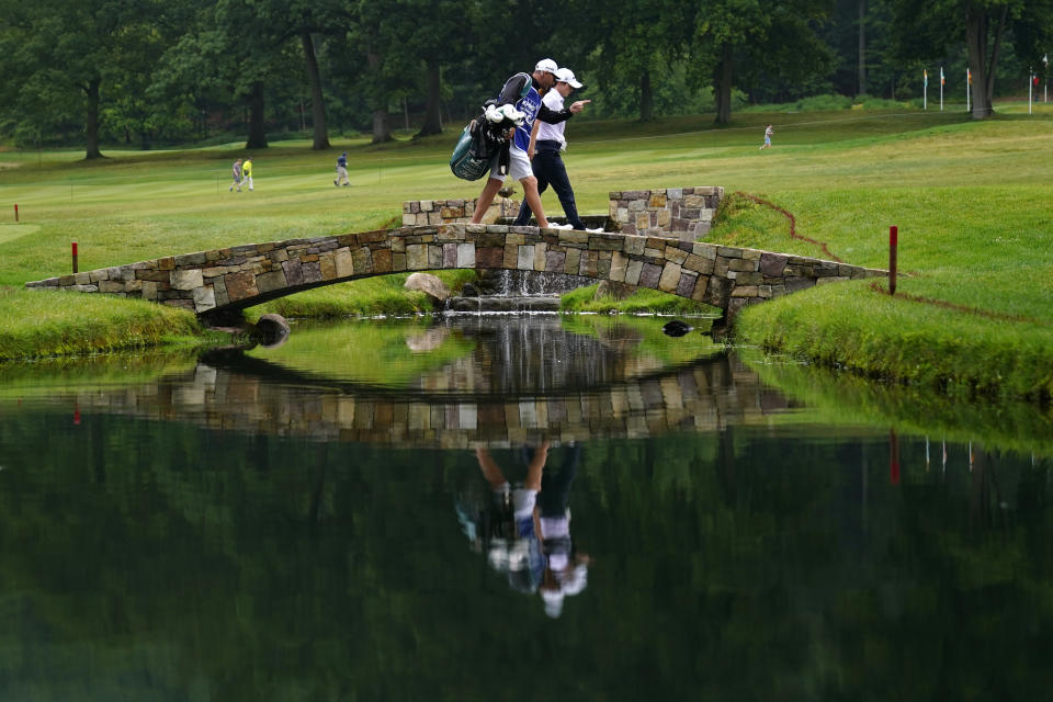 Leona Maguire, of Ireland, crosses a bridge with her caddie on the 18th hole during the second round of the Women's PGA Championship golf tournament, Friday, June 23, 2023, in Springfield, N.J. (AP Photo/Matt Rourke)