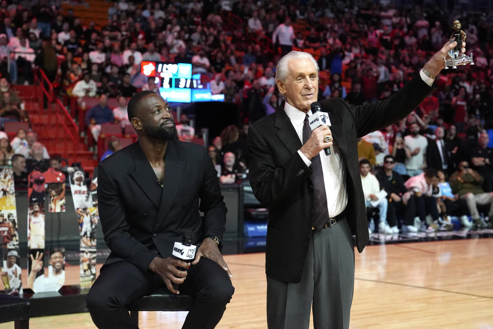 Former Miami Heat player Dwyane Wade, left, looks on as Heat President Pat Riley holds a bobblehead doll of Wade during a ceremony honoring Wade's career and his induction into the 2023 Naismith Memorial Basketball Hall of Fame during halftime of an NBA basketball game between the Heat and the Charlotte Hornets, Sunday, Jan. 14, 2024, in Miami. (AP Photo/Lynne Sladky)