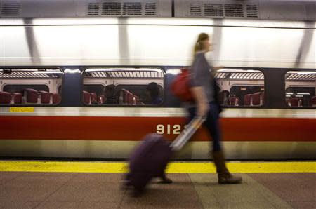 A traveler walks past a train at Grand Central Station in New York November 27, 2013. REUTERS/Eric Thayer