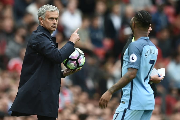 Manchester United's manager Jose Mourinho holds onto the ball as Manchester City's Raheem Sterling tries to retrieve it during their English Premier League match, at Old Trafford, on September 10, 2016