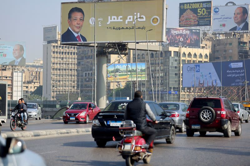 FILE PHOTO: Vehicles drive past posters of presidential candidate and current Egyptian President Abdel Fattah al-Sisi and presidential candidate Hazem Omar, head of the People's Republican Party (PRP), displayed on billboards in Cairo