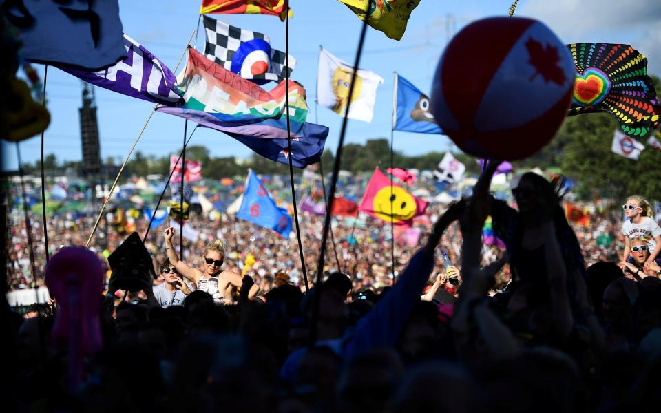 Colourful flags flying in the jam-packed crowd during Chic's set - Credit: Reuters