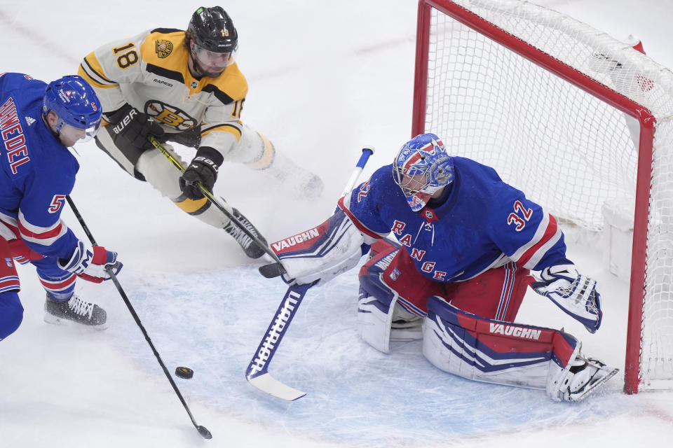 Boston Bruins center Pavel Zacha (18) is unable to score as New York Rangers goaltender Jonathan Quick (32) deflects the puck while defenseman Chad Ruhwedel (5) defends in the first period of an NHL hockey game, Thursday, March 21, 2024, in Boston. (AP Photo/Steven Senne)