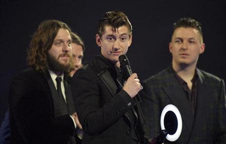 Alex Turner (C) of the Arctic Monkeys talks after being presented with the British Album award at the BRIT Awards, celebrating British pop music, at the O2 Arena in London February 19, 2014. Seen are Nick O'Malley (L) and Matt Helders (R). REUTERS/Toby Melville