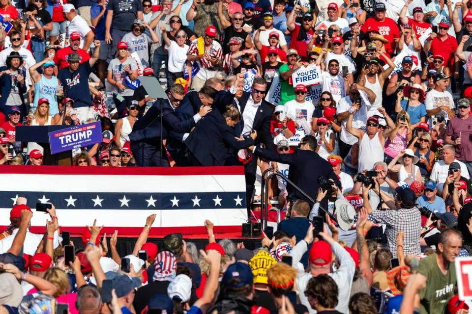 A bloodied Donald Trump is rushed off stage by Secret Service agents after shots were fired at a campaign rally on Saturday, July 13 2024, in Butler, Pa. The former president was declared ÒfineÓ by his campaign, and the gunman was killed by Secret Service snipers. The explosion of political violence further inflamed the campaign for the White House.