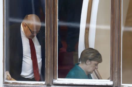 Leader of the Christian Democratic Union of Germany (CDU) Angela Merkel and Chief of Staff of the German Chancellery Peter Altmaier are seen through the window prior to the the CDU/CSU and Free Democratic Party (FDP) exploratory talks about forming a new coalition government in Berlin, Germany, October 18, 2017. REUTERS/Hannibal Hanschke