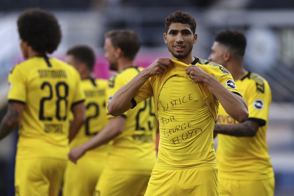 FILE - In this Sunday, May 31, 2020 file photo Achraf Hakimi Mouh of Borussia Dortmund celebrates scoring his teams fourth goal of the game with 'Justice for George Floyd' written on his under shirt during the German Bundesliga soccer match between SC Paderborn 07 and Borussia Dortmund at Benteler Arena in Paderborn, Germany. Since George Floyd's death in the U.S. state of Minnesota last week, his face has been painted on walls from Nairobi, Kenya to Idlib, Syria. Floyd's name has been inked on the shirts of soccer players and chanted by crowds from London and Cape Town to Tel Aviv and Sydney. (Lars Baron/Pool via AP, File)