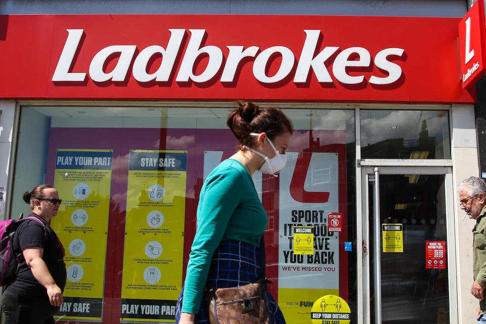 LONDON, UNITED KINGDOM - 2020/06/13: A woman wearing a face mask walks past a branch of Ladbrokes in London. (Photo by Dinendra Haria/SOPA Images/LightRocket via Getty Images)