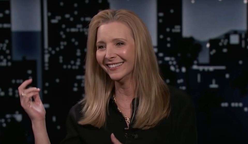 Woman gesturing during a television interview, displaying a friendly demeanor