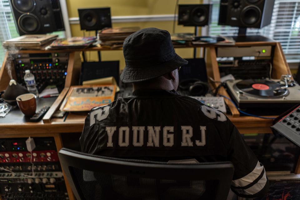 Slum Village member Young RJ listens through a collection of records in search of samples to use for the group's next album at a home recording studio in Milford on Thursday, May 9, 2024.