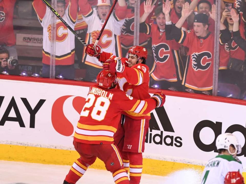 Flames forward Johnny Gaudreau, right, scored the game-winning goal in a 3-2 overtime win in game seven on Sunday in Calgary, to advance to the second round of the Stanley Cup playoffs. (Candice Ward/USA Today Sports via Reuters - image credit)