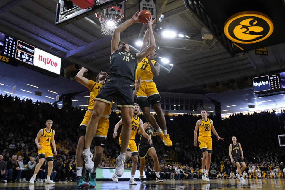 Purdue center Zach Edey (15) grabs a rebound in front of Iowa guard Tony Perkins (11) during the first half of an NCAA college basketball game, Saturday, Jan. 20, 2024, in Iowa City, Iowa. Purdue won 84-70. (AP Photo/Charlie Neibergall)