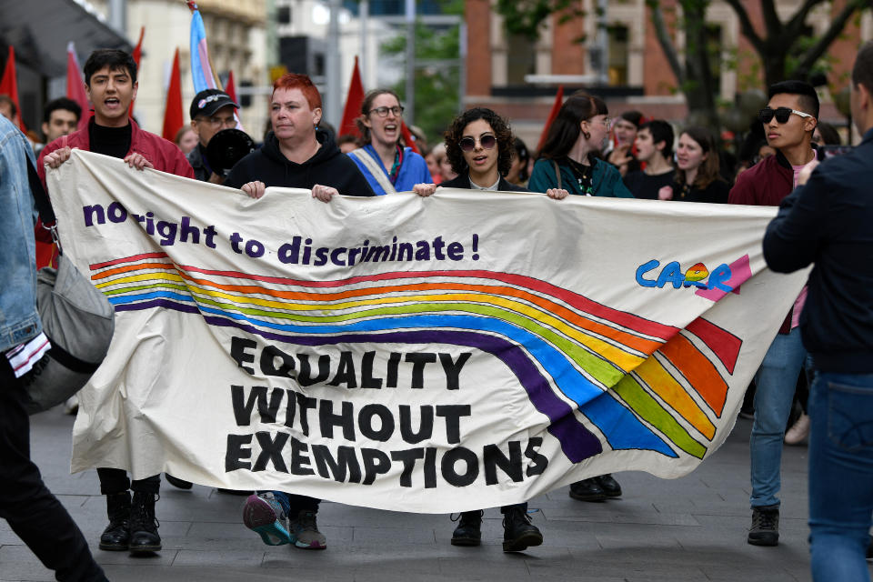 Protestors holding a banner are seen marching during a rally to protest against the Religious Discrimination Bill at Sydney Town Hall in Sydney.