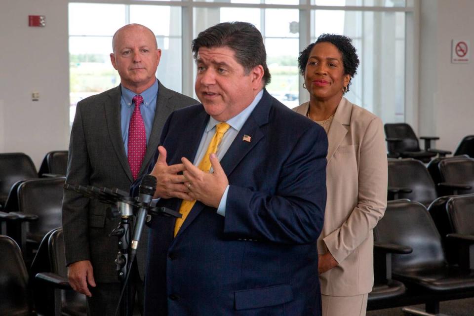 Illinois Gov. J.B. Pritzker answers questions from the press about the MidAmerica St. Louis Airport expansion on Tuesday, June 13, 2023 at MidAmerica St. Louis Airport. Behind him stand MidAmerica St. Louis Airport Director Bryan Johnson, left, and Illinois Lt. Gov. Juliana Stratton.