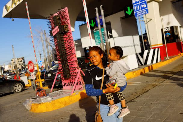 PHOTO: Angeldry Galeno, a Venezuelan migrant trying to apply for asylum in the United States holds her daughter as she walks near the border between Mexico and the United States, in Ciudad Juarez, Mexico, Feb. 24, 2023. (Jose Luis Gonzalez/Reuters)