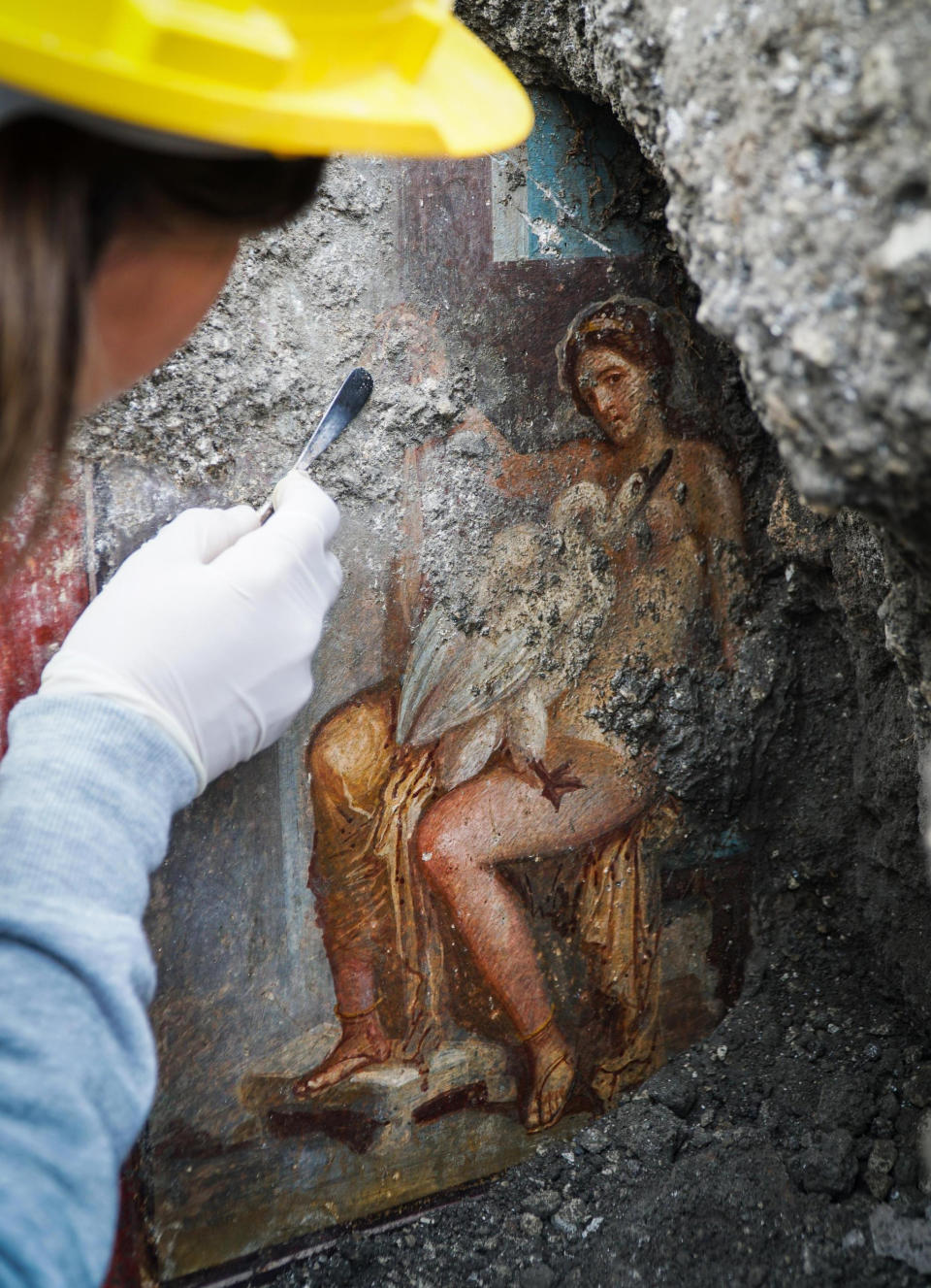 CORRECTS TITLE OF THE FIGURE SHOWN IN THE FRESCO, FROM GODDESS TO QUEEN OF SPARTA - An archeologist cleans up the fresco ''Leda e il cigno'' (Leda and the swan) discovered last Friday in the Regio V archeological area in Pompeii, near Naples, Italy, Monday, Nov. 19, 2018. The fresco depicts a story and art subject of Greek mythology, with Queen of Sparta Leda being impregnated by Zeus - Jupiter in Roman mythology - in the form of a swan. (Cesare Abbate/ANSA via AP)